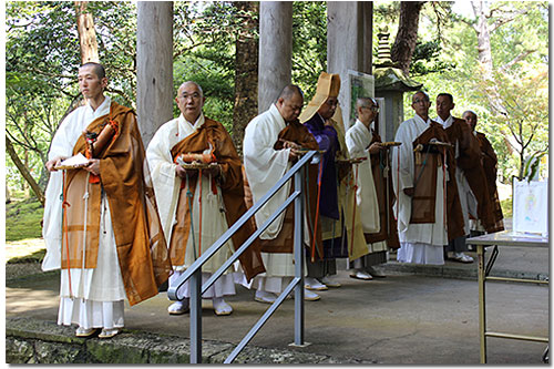 法要前、山門でのお練の行列を迎える住職と僧侶のみなさん。